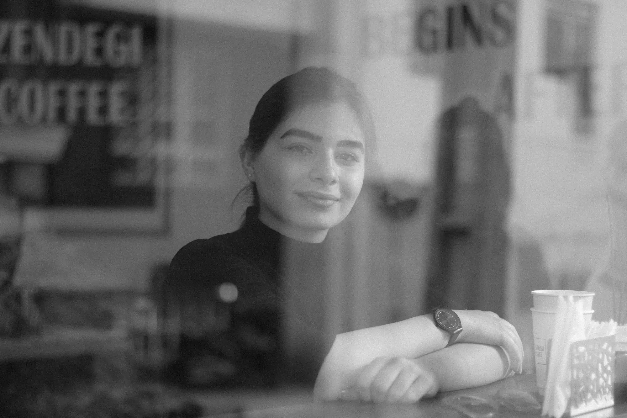 Cafe owner smiling behind the counter of her leased shop